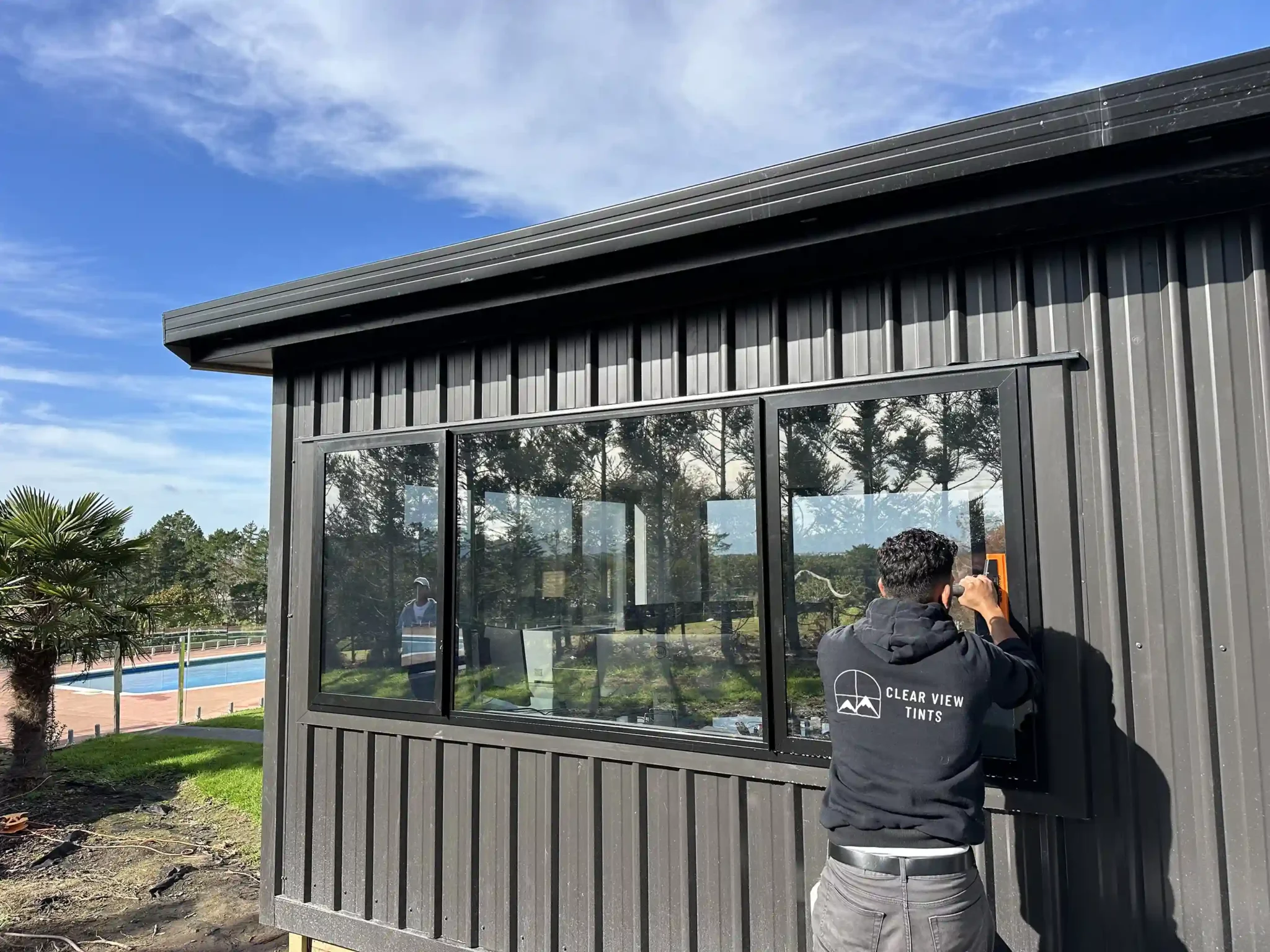 Expert window film installer working on Bucklands Beach property glass