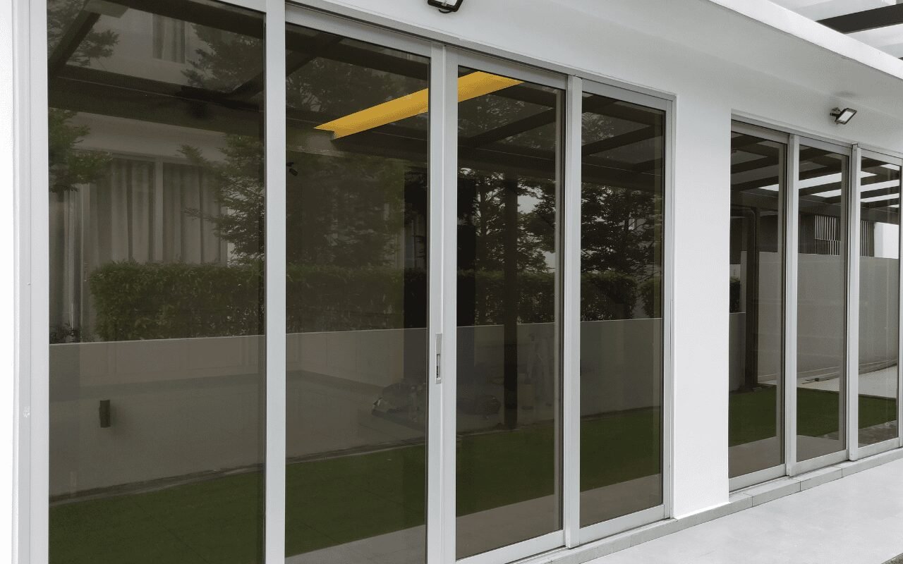 Window film installer working on office glazing in a safely cleared work area